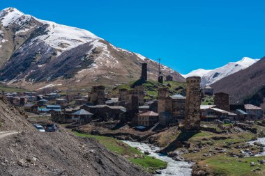 Ushguli Dağı eteğindeki Ushguli köyünün manzarası. Shkhara. Resimli ve muhteşem bir sahne. Gürcistan, Ushguli 'deki taş kuleler ve eski evler. Seyahat.