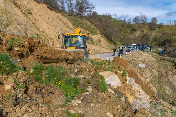 Svaneti, Gürcistan - 05 Mayıs 2021: Traktör heyelandan yolu temizliyor. Dağlar