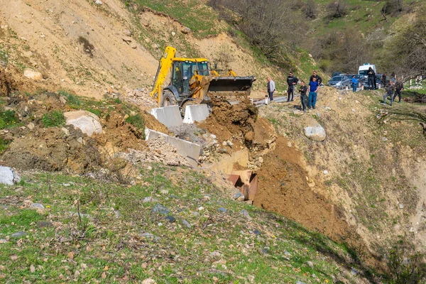 Svaneti, Gürcistan - 05 Mayıs 2021: Traktör heyelandan yolu temizliyor. Dağlar