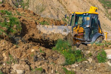 Traktör heyelandan yolu temizliyor. Svaneti, Georgia