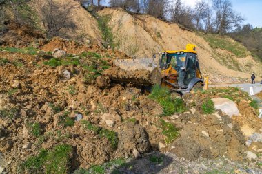 Traktör heyelandan yolu temizliyor. Svaneti, Georgia