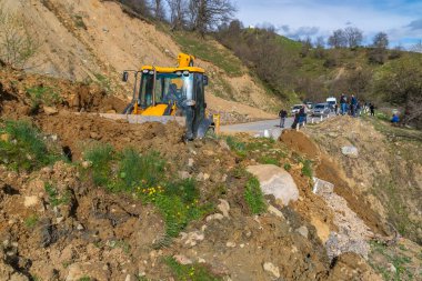 Svaneti, Gürcistan - 05 Mayıs 2021: Traktör heyelandan yolu temizliyor. Dağlar