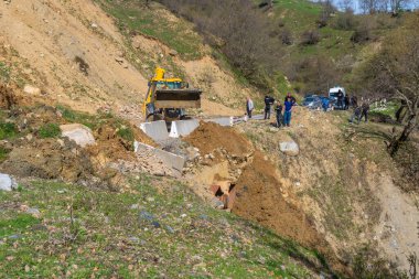 Svaneti, Gürcistan - 05 Mayıs 2021: Traktör heyelandan yolu temizliyor. Dağlar