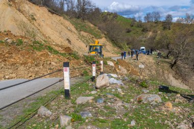 Svaneti, Gürcistan - 05 Mayıs 2021: Traktör heyelandan yolu temizliyor