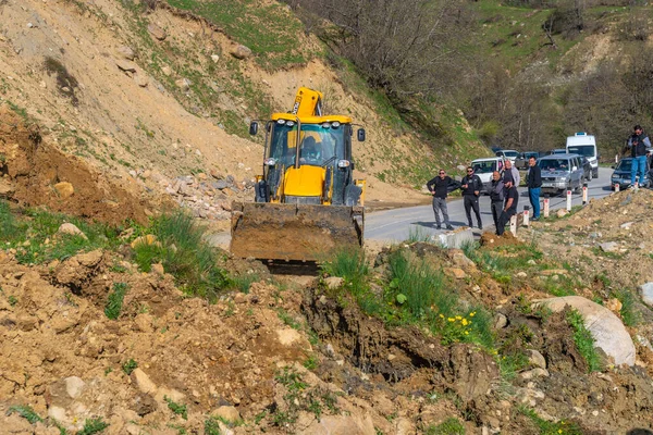 Svaneti, Georgia - 05 de mayo de 2021: El tractor despeja el camino de un deslizamiento de tierra — Foto de Stock