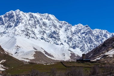 Shkhara Mt. eteklerindeki Ushguli köyünün görünümü. Lamaria Manastırı, eski kaya kulesi. Seyahat