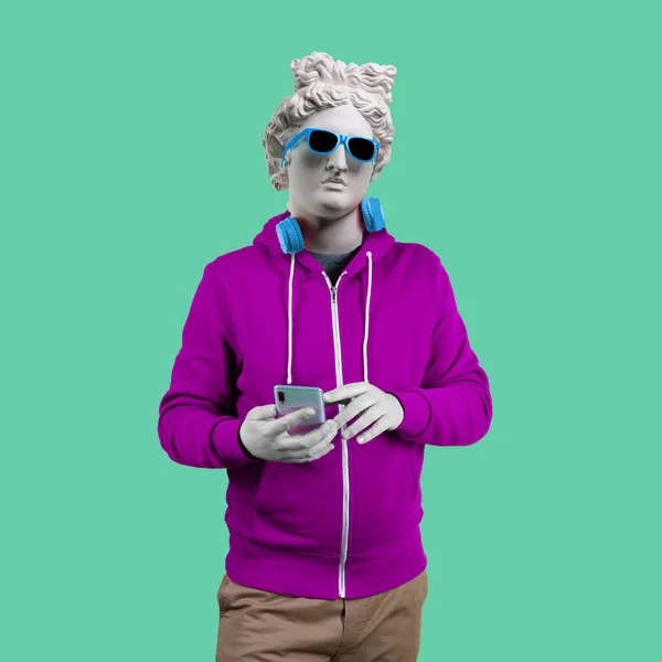 Apollo 'nun mavi gözlüklü ve kulaklıklı alçı heykeli. Minimum konsept sanat. Pembe bir arka planda.