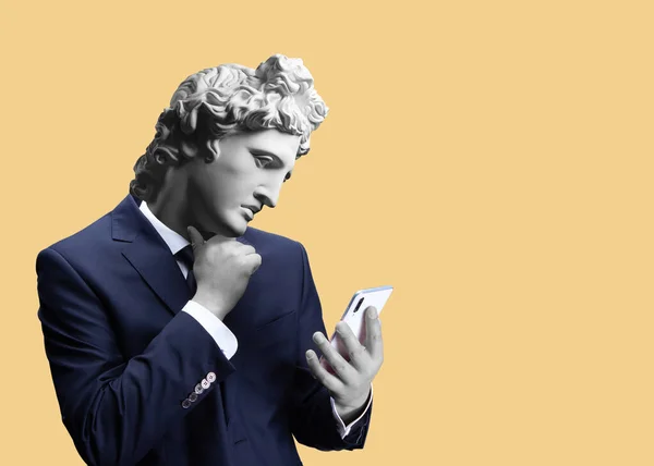 Modern sanat kolajı. Bir iş adamının cep telefonu taşıyan portresini uygulama mesajları kullanarak tasvir et. Apollo 'nun alçıtaşı başı. Takım elbiseli adam. 