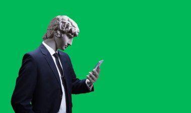 Modern art collage. Concept portrait of a  businessman  holding mobile smartphone using app texting sms message. Gypsum head of of Antinous. Man in suit. On a green background. clipart