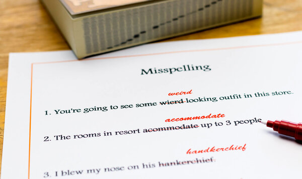 лист с исправлением орфографии на английском языке на столе
