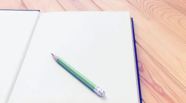 Ahşap masa üstünde beyaz defter kalem — Stok fotoğraf