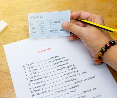 Degrade lig ile kahverengi ahşap masa üzerinde İngilizce kartı tutan el