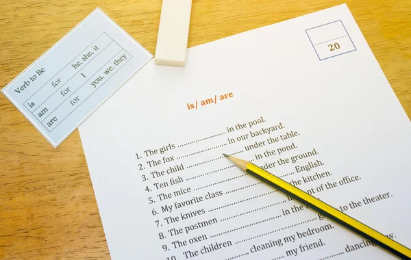 English exercise on brown wooden desk with gradient light — стоковое фото