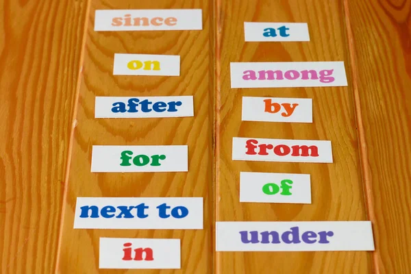 木制桌子上彩色英语介词卡片 用于教育背景 — 图库照片