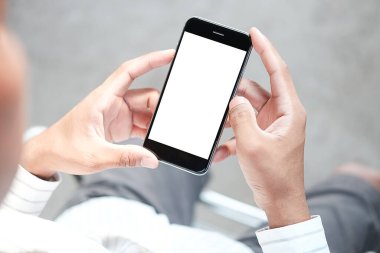 Metin mesajınız veya bilgi içeriğiniz için boş ekranlı akıllı telefonu tutan erkek eli görüntüsü, şehir ortamında cep telefonundan mesaj okuyan kadın görüntüsü. 