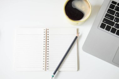 Not defteri, dizüstü bilgisayar ve kahve fincanı fare notlu üst görünüm ofis malzemeleri. Boş ekran cep telefonu ve beyaz masa çalışma alanı üzerindeki malzemeler ve kopyalama alanı..