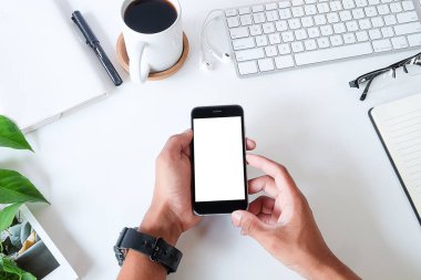 Not defteri, dizüstü bilgisayar ve kahve fincanı fare notlu üst görünüm ofis malzemeleri. Boş ekran cep telefonu ve beyaz masa çalışma alanı üzerindeki malzemeler ve kopyalama alanı..