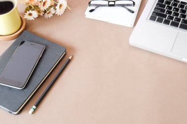 Not defteri, dizüstü bilgisayar ve kahve fincanı fare notlu üst görünüm ofis malzemeleri. Boş ekran cep telefonu ve beyaz masa çalışma alanı üzerindeki malzemeler ve kopyalama alanı..
