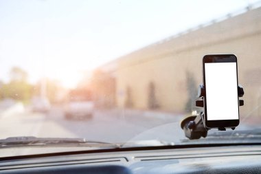 Kesilmiş görüntü. Şoför araba kullanırken telefonu kullanıyor. Yuvarlak kenarlı modern akıllı telefon. Model için izole ekran. Arka planda araba navigasyon görüntüsü. 