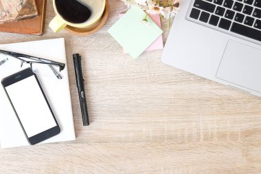 Not defteri, dizüstü bilgisayar ve kahve fincanı fare notlu üst görünüm ofis malzemeleri. Boş ekran cep telefonu ve beyaz masa çalışma alanı üzerindeki malzemeler ve kopyalama alanı..