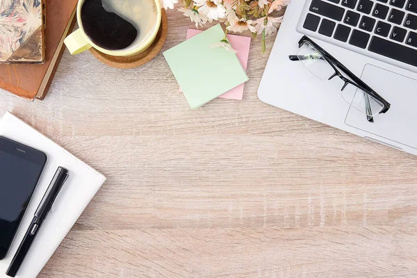 Not defteri, dizüstü bilgisayar ve kahve fincanı fare notlu üst görünüm ofis malzemeleri. Boş ekran cep telefonu ve beyaz masa çalışma alanı üzerindeki malzemeler ve kopyalama alanı..