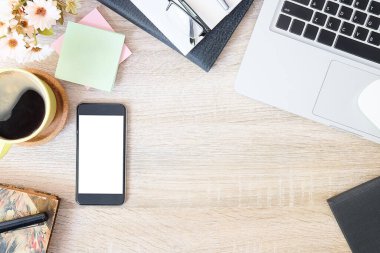 Not defteri, dizüstü bilgisayar ve kahve fincanı fare notlu üst görünüm ofis malzemeleri. Boş ekran cep telefonu ve beyaz masa çalışma alanı üzerindeki malzemeler ve kopyalama alanı..