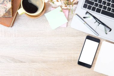 Not defteri, dizüstü bilgisayar ve kahve fincanı fare notlu üst görünüm ofis malzemeleri. Boş ekran cep telefonu ve beyaz masa çalışma alanı üzerindeki malzemeler ve kopyalama alanı..