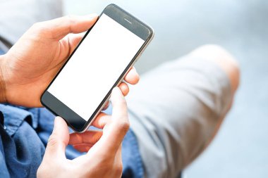 Metin mesajınız veya bilgi içeriğiniz için boş ekranlı akıllı telefonu tutan erkek eli görüntüsü, şehir ortamında cep telefonundan mesaj okuyan kadın görüntüsü. 