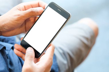 Metin mesajınız veya bilgi içeriğiniz için boş ekranlı akıllı telefonu tutan erkek eli görüntüsü, şehir ortamında cep telefonundan mesaj okuyan kadın görüntüsü. 
