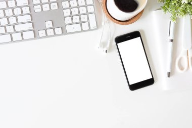 Not defteri, dizüstü bilgisayar ve kahve fincanı fare notlu üst görünüm ofis malzemeleri. Boş ekran cep telefonu ve beyaz masa çalışma alanı üzerindeki malzemeler ve kopyalama alanı..