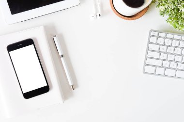 Not defteri, dizüstü bilgisayar ve kahve fincanı fare notlu üst görünüm ofis malzemeleri. Boş ekran cep telefonu ve beyaz masa çalışma alanı üzerindeki malzemeler ve kopyalama alanı..