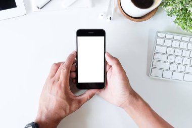 Not defteri, dizüstü bilgisayar ve kahve fincanı fare notlu üst görünüm ofis malzemeleri. Boş ekran cep telefonu ve beyaz masa çalışma alanı üzerindeki malzemeler ve kopyalama alanı..