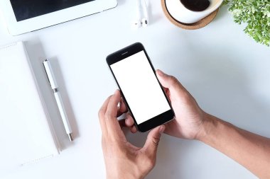 Not defteri, dizüstü bilgisayar ve kahve fincanı fare notlu üst görünüm ofis malzemeleri. Boş ekran cep telefonu ve beyaz masa çalışma alanı üzerindeki malzemeler ve kopyalama alanı..