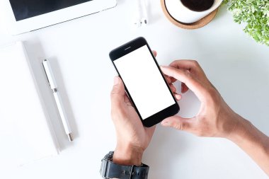 Not defteri, dizüstü bilgisayar ve kahve fincanı fare notlu üst görünüm ofis malzemeleri. Boş ekran cep telefonu ve beyaz masa çalışma alanı üzerindeki malzemeler ve kopyalama alanı..
