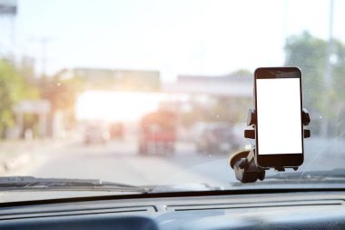 Kesilmiş görüntü. Şoför araba kullanırken telefonu kullanıyor. Yuvarlak kenarlı modern akıllı telefon. Model için izole ekran. Arka planda araba navigasyon görüntüsü. 