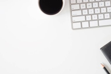 Not defteri, dizüstü bilgisayar ve kahve fincanı fare notlu üst görünüm ofis malzemeleri. Boş ekran cep telefonu ve beyaz masa çalışma alanı üzerindeki malzemeler ve kopyalama alanı.