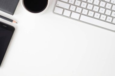 Not defteri, dizüstü bilgisayar ve kahve fincanı fare notlu üst görünüm ofis malzemeleri. Boş ekran cep telefonu ve beyaz masa çalışma alanı üzerindeki malzemeler ve kopyalama alanı.