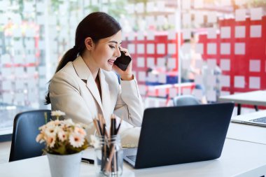 Modern ofiste bilgisayarla çalışan Asyalı kadın..