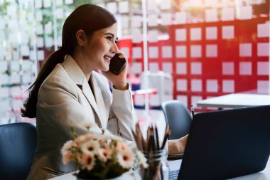 Modern ofiste bilgisayarla çalışan Asyalı kadın..