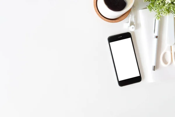 Not defteri, dizüstü bilgisayar ve kahve fincanı fare notlu üst görünüm ofis malzemeleri. Boş ekran cep telefonu ve beyaz masa çalışma alanı üzerindeki malzemeler ve kopyalama alanı..