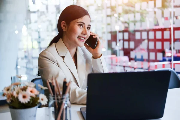 Modern ofiste bilgisayarla çalışan Asyalı kadın..