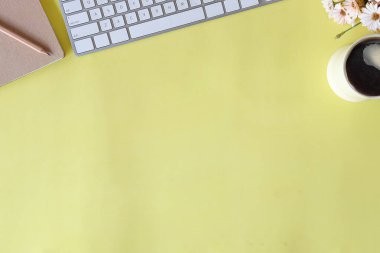 Boş defter, bilgisayar klavyesi ve diğer ofis malzemeleriyle üst kattaki ofis masasında. Kopyalama alanı ile, düz yatar.