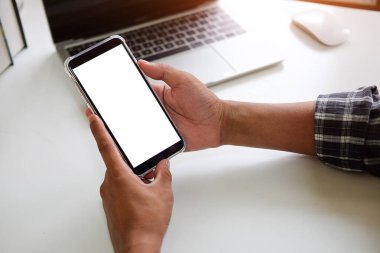 Metin mesajınız veya bilgi içeriğiniz için boş ekranlı akıllı telefonu tutan erkek eli görüntüsü, şehir ortamında cep telefonundan mesaj okuyan kadın görüntüsü.