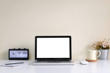 Minimal workspace with white screen computer and office supplies on white table.	