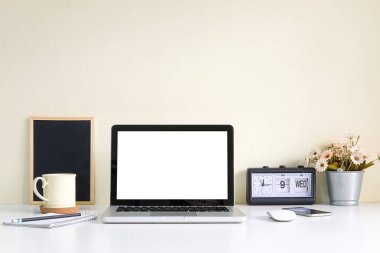 Minimal workspace with white screen computer and office supplies on white table.	