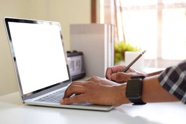 Bilgisayar dizüstü bilgisayarı, kahve fincanı, kulaklık ve ahşap masadaki kitaplarla yaratıcı bir iş yeri.