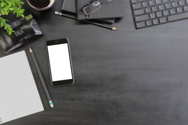 Not defteri, dizüstü bilgisayar ve kahve fincanı fare notlu üst görünüm ofis malzemeleri. Boş ekran cep telefonu ve masa başı çalışma alanı üzerindeki malzemeler ve kopyalama alanı..