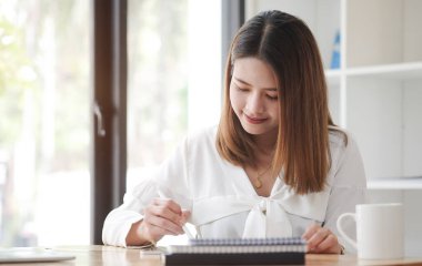 Ofiste bilgisayar laptopuyla çalışan neşeli iş kadını..
