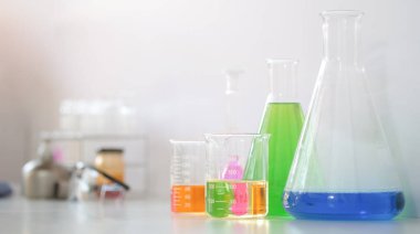 Laptop bilgisayar ve bilimsel laboratuvar ekipmanları beyaz masada..