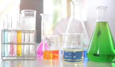 Laptop bilgisayar ve bilimsel laboratuvar ekipmanları beyaz masada..